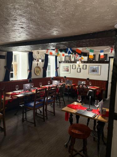 a dining room with tables and chairs and flags at Masons Arms in Skipton