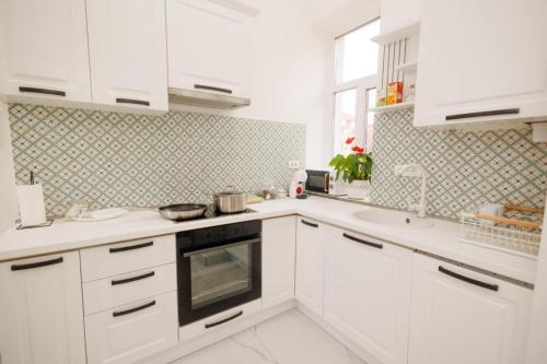 a white kitchen with white cabinets and appliances at Fabulous Bulevard Ultracentral Apartament in Arad