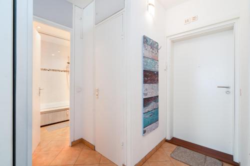 a hallway with white walls and a white door at Panoramic App B06-1 in Sierksdorf