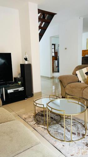 a living room with two tables and a couch at Sibusi Guesthouse in Richards Bay