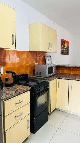 a kitchen with a black stove and a microwave at Sibusi Guesthouse in Richards Bay