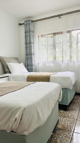 a bedroom with two beds and a window at Sibusi Guesthouse in Richards Bay
