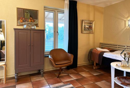 a bedroom with a bed and a chair and a window at Villa Beddingestrand in Beddinge Strand