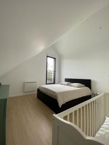 une chambre blanche avec un lit et une fenêtre dans l'établissement Maison Neuve Piriac-sur-Mer, à Piriac-sur-Mer