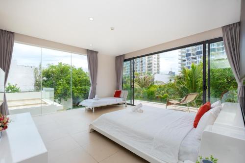 ein Schlafzimmer mit großem Bett und großen Fenstern in der Unterkunft VILLA ARIA RESORT, THE SEA BY 10-50m,Biển và hồ bơi riêng in Vũng Tàu