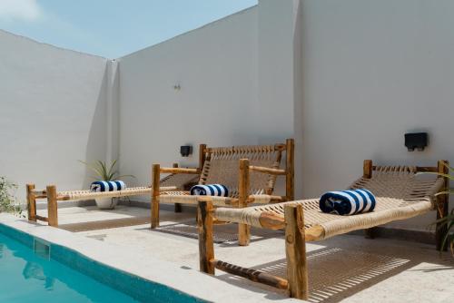 a group of chairs sitting next to a swimming pool at Leparadis Zanzibar Boutique Hotel in Jambiani
