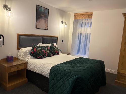 a bedroom with a bed and a window at Masons Arms in Skipton