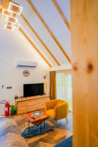 a living room with a tv and a couch and a table at Family Resort Plitvice Lakes in Rastovača