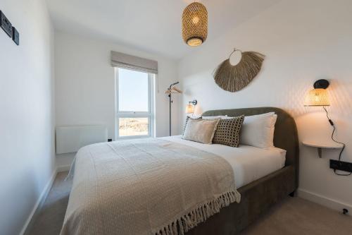 a bedroom with a large bed and a window at Gwel Y Mor Penthouse By Birch Stays New Home in Amlwch