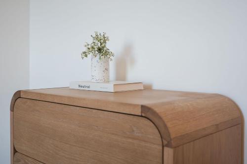 a wooden cabinet with a vase on top of it at Gwel Y Mor Penthouse By Birch Stays New Home in Amlwch