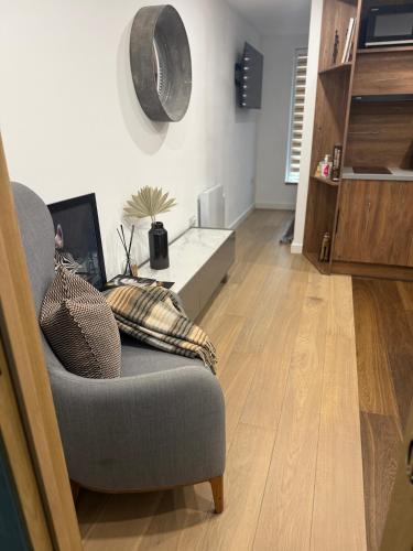 a living room with a chair and a table at Modern apartment, free parking within walking distance of Churchill Hospital in Oxford