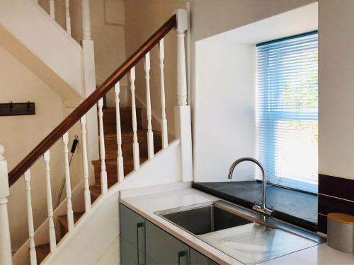 una cucina con lavandino e scala di Mount Cottage a Newcastle Emlyn