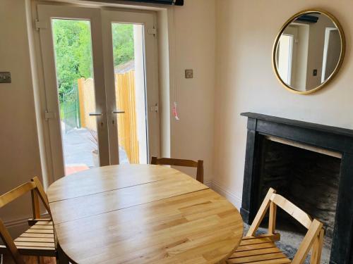 una sala da pranzo con tavolo in legno e specchio di Mount Cottage a Newcastle Emlyn