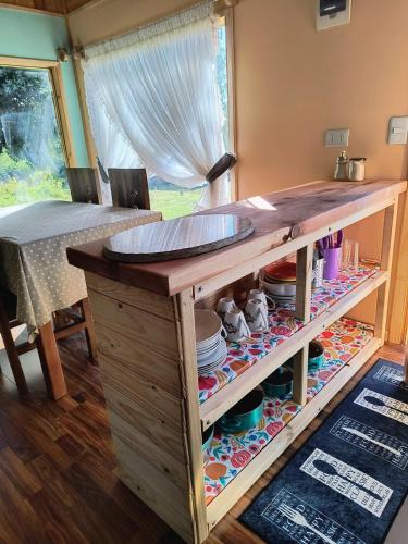 a kitchen with a wooden counter with dishes on it at Casa entré Fundos in Lago Ranco