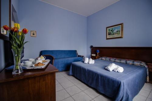a hotel room with two beds and a couch at Miramare Hotel in Catania