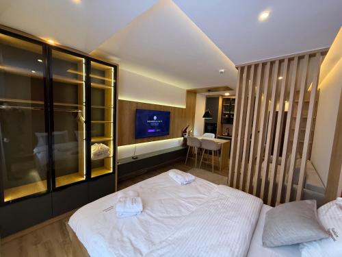 a bedroom with a white bed and a television at Fashion Residence Hill in Kopaonik