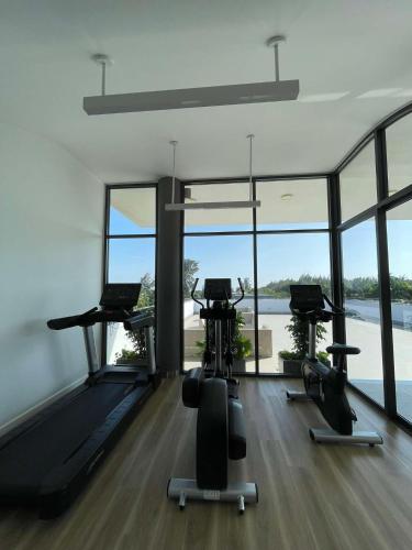 a gym with treadmills and exercise bikes in a room with windows at 2-min from Private Beach Sanctuary Villa Ho Tram in Ho Tram