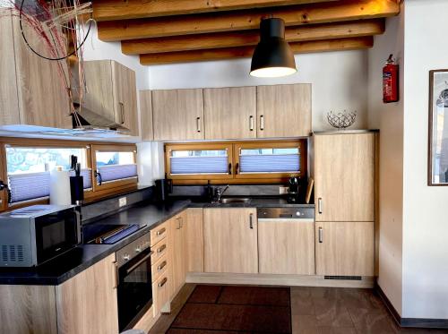 a kitchen with wooden cabinets and a microwave at Mountain Apart Katzenkopf in Leutasch
