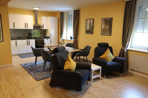 a living room with a table and chairs and a kitchen at Hotel Deutscher Hof in Babenhausen