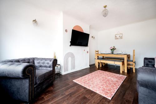 a living room with a couch and a table at Cosy 3-Bed Home l Free Parking l WiFi l Sleeps 8 l Family Friendly l Hosted by The Cosy Corner Nationwide in Bolton