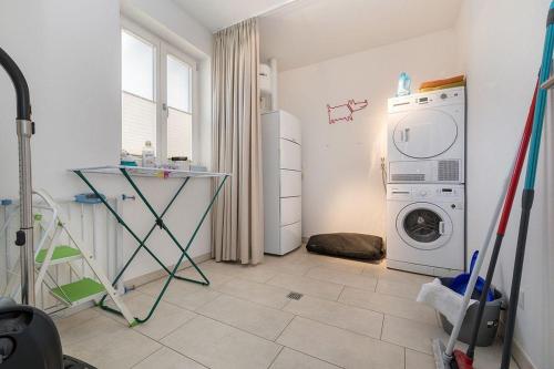 a laundry room with a washing machine and a table at Haus Leuchtturmblick Dünenresidenz-Glowe in Glowe