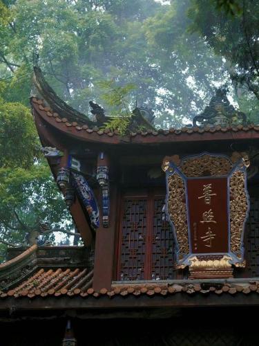 a building with a chinese sign on top of it at 福来小院民宿 in Jiezi Ancient Town