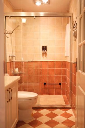 a bathroom with a toilet and a glass shower at 福来小院民宿 in Jiezi Ancient Town