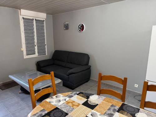 a living room with a couch and a table and chairs at Gîte Le Tilleul in Le Tilleul