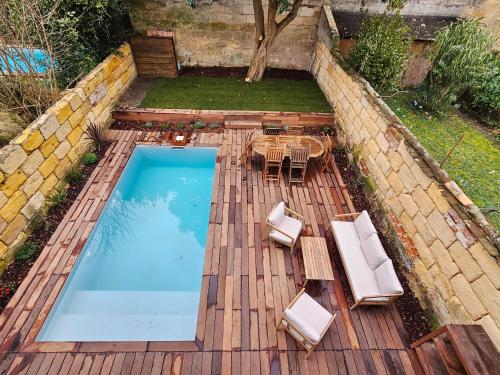 an overhead view of a pool with chairs and a table at Villa Nomade - Bordeaux center 180m2, 4 rooms, Garden & Pool in Bordeaux