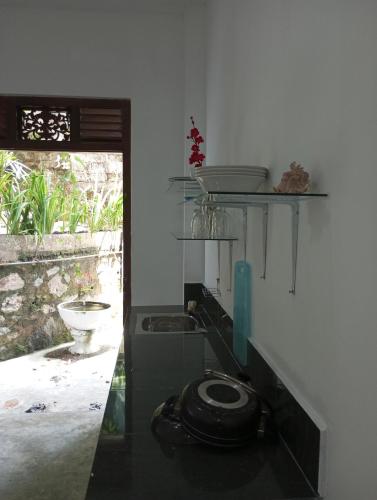 a bathroom with a toilet in a room with a window at sajini home stay in Pilana