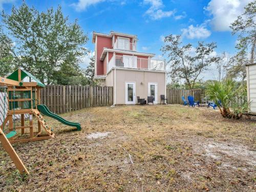 a house with a fence and a playground at Sandcastle on Castile in Panama City Beach