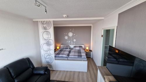 een slaapkamer met een bed en een bank in een kamer bij Harztraum in Altenau