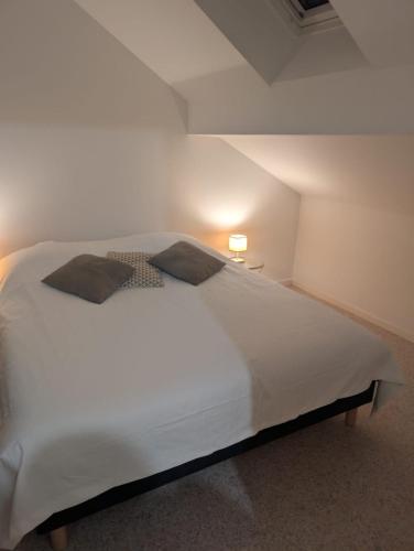 une chambre avec un grand lit blanc dans un grenier dans l'établissement Appartement calme hyper centre, à Remiremont