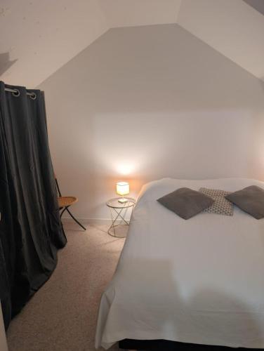 une chambre avec un lit et une table avec une lampe dans l'établissement Appartement calme hyper centre, à Remiremont