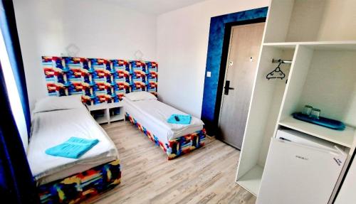 a small bedroom with two beds and a refrigerator at Mihai Mihai in Constanţa