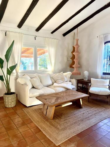 a living room with a white couch and a coffee table at Finca es Born - vistas panorámicas in Esporles