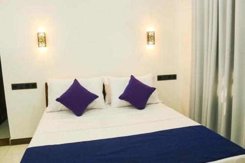 a bed with purple and white pillows in a room at Nature Villa Guest House in Matara