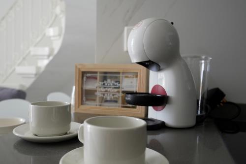 two cups on a counter next to a coffee maker at Viktorja106 in Senglea