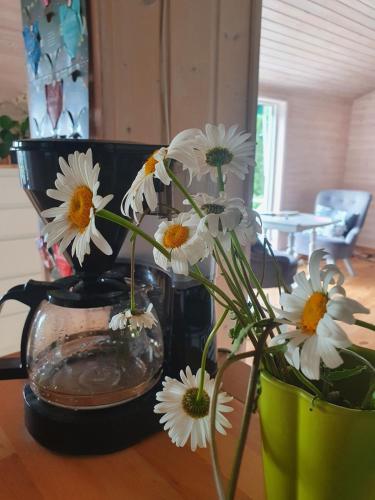 a vase filled with white flowers on a table at House with beautiful lake view in Alingsås