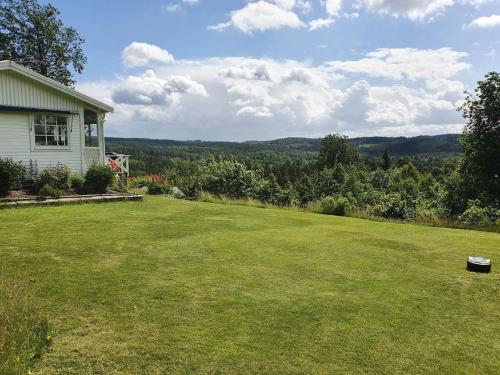 a yard with a house and a field of grass at House with beautiful lake view in Alingsås