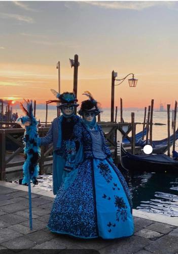two women dressed in costumes standing next to a dock at Castelletto in Castello dʼAviano