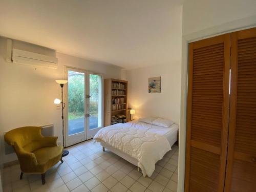 une chambre avec un lit, une chaise et une fenêtre dans l'établissement Maison Landaise au Calme - Proche Golf d'Hossegor, 3 Chambres, Jardin, Terrasse, Animaux Admis - FR-1-413-200, à Capbreton