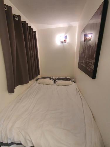 un lit blanc dans une chambre avec des fenêtres dans l'établissement L'Estérel, à Cannes