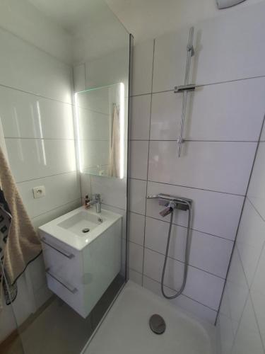une salle de bain blanche avec un lavabo et une douche dans l'établissement L'Estérel, à Cannes