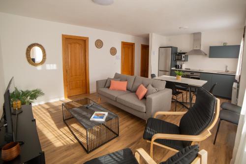 ein Wohnzimmer mit Sofa und Tisch in der Unterkunft Casa Tierra Viva, junto a Bardenas Reales y Sendaviva in Valtierra