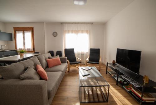 ein Wohnzimmer mit Couch und Flachbildfernseher in der Unterkunft Casa Tierra Viva, junto a Bardenas Reales y Sendaviva in Valtierra