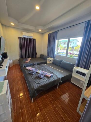 ein Wohnzimmer mit Couch und großem Fenster in der Unterkunft Chaba4-1 in Ban Nong Bua Noi