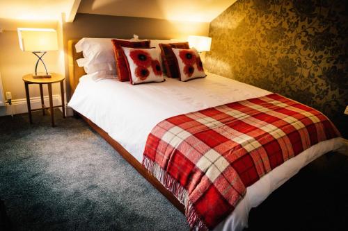 a bedroom with a bed with a blanket and pillows at Docker's Digs in Gateshead