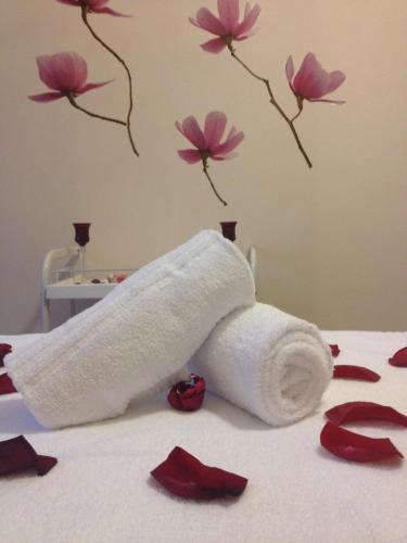 a roll of toilet paper on a bed with flowers at San Gabriele in Loreto