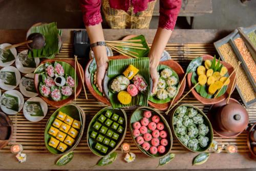 a person standing at a table with plates of food at Hotel Tugu Blitar in Blitar